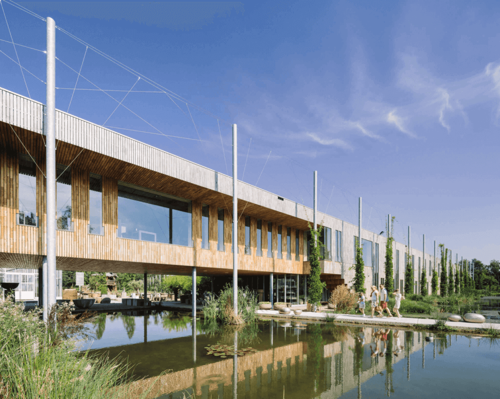 Duurzaam gebouw met vijver en wandelpad.