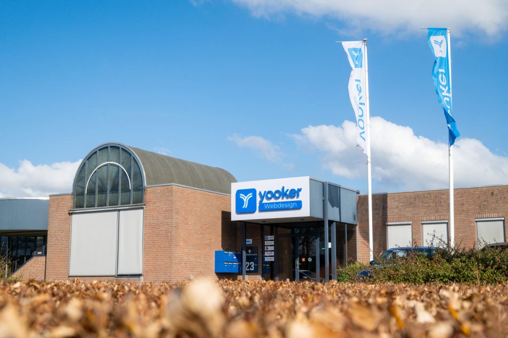 Bedrijfspand met logo en vlaggen.