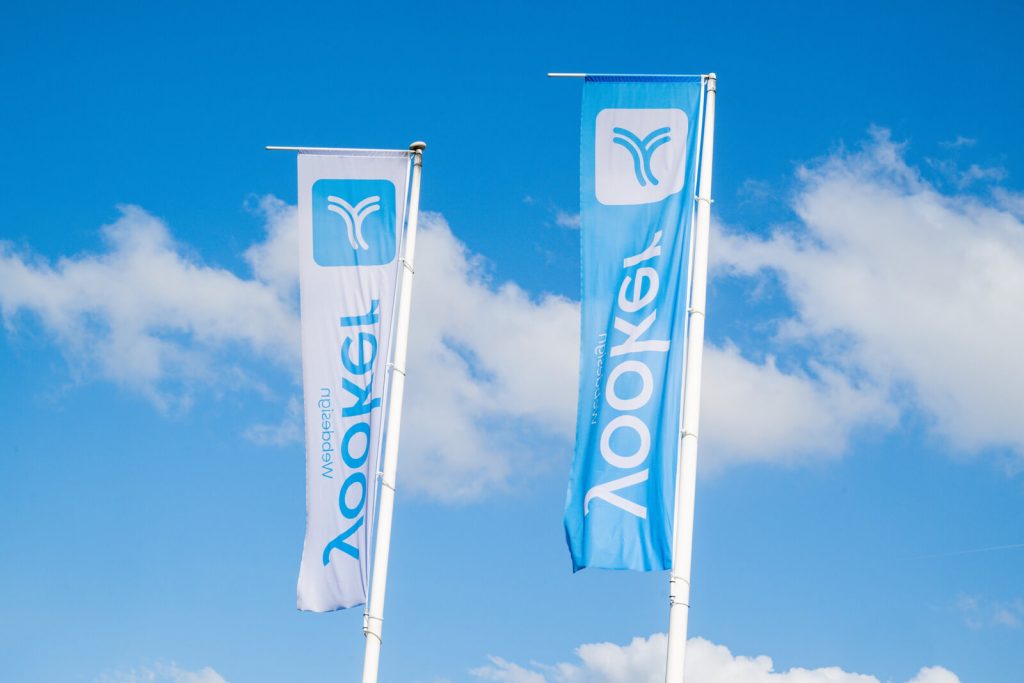 Twee verticale blauwe en witte vlaggen tegen blauwe lucht.