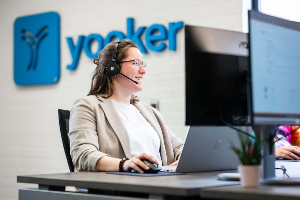 Medewerker helpt klant via headset op kantoor