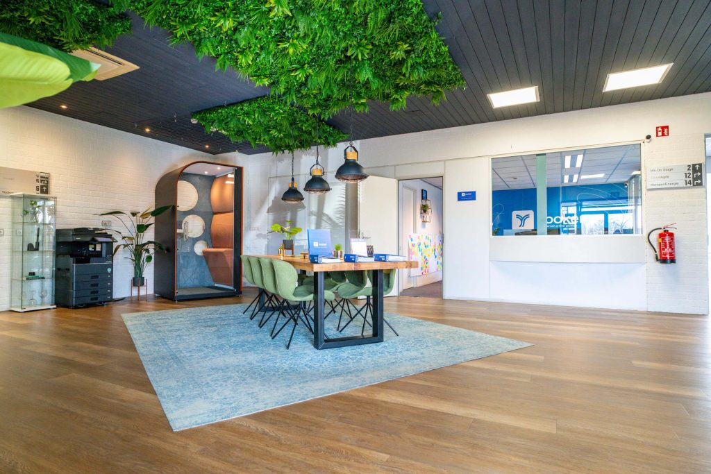 Modern kantoorinterieur met planten en vergadertafel.